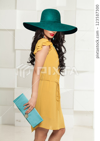 Beautiful woman wearing blue green hat posing indoor Beautiful woman wearing blue green hat posing indoor 123587300