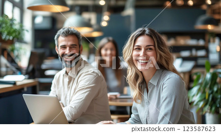 Smiling business professionals collaborating in a modern office, fostering teamwork, productivity, and workplace success. 123587623