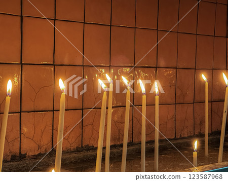 Burning Votive Candles against Orange Wall Background in Calm Setting Burning Votive Candles against Orange Wall Background in Calm Setting 123587968