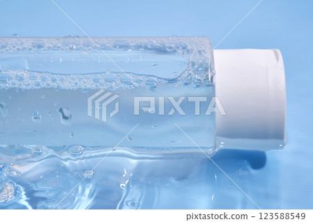 Bottle with cosmetic gel for face and body on blue background in water. 123588549