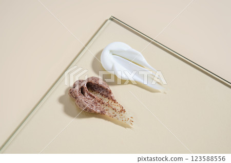 A smear of white cream and coffee cream scrub on a beige background. 123588556