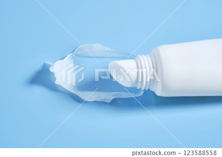 White lip balm in a tube on a blue background. The texture. White lip balm in a tube on a blue background. The texture. 123588558