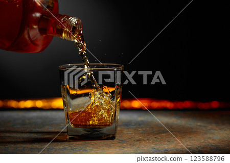 Whiskey is poured into a crystal glass. 123588796