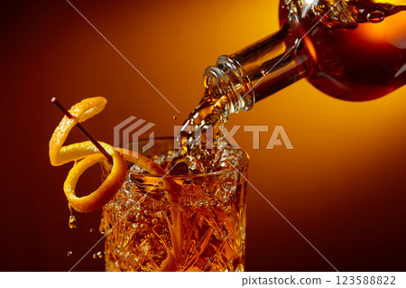 Whiskey or bourbon pouring into a crystal glass. Whiskey or bourbon pouring into a crystal glass. 123588822