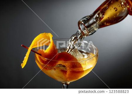 Old-fashioned cocktail garnished with orange peel. Old-fashioned cocktail garnished with orange peel. 123588823