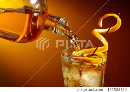 Old-fashioned cocktail garnished with orange peel. 123588824