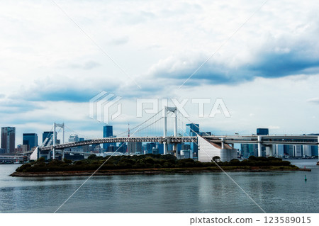 The Rainbow Bridge stretches across Tokyo Bay in Odaiba, creating a beautiful cityscape under cloudy skies. The Rainbow Bridge stretches across Tokyo Bay in Odaiba, creating a beautiful cityscape under cloudy skies. 123589015