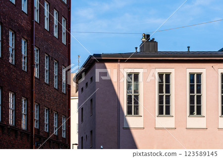 Old meets new in Helsinki: A study of brick and stucco buildings under a clear blue sky. 123589145