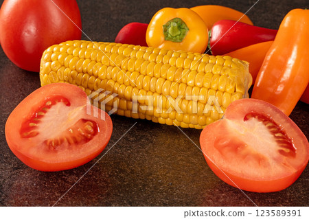 Fresh organic vegetable mix with tomatoes, bell peppers, and corn on black background 123589391