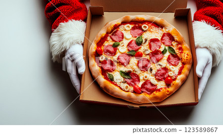 Santa hands are holding a pizza box with delicious pizza inside. Concept of festive holiday food delivery. 123589867