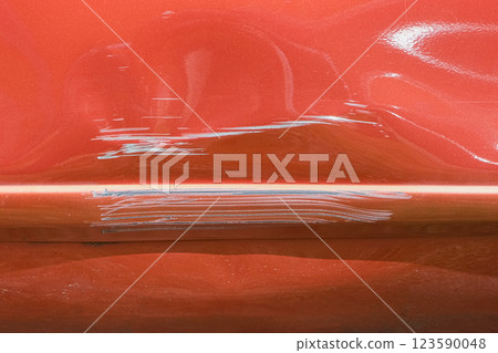 Close up of a red car with multiple visible scratches and paint damage The scratches expose the underlying metal, creating a contrast against the glossy surface. Perfect for automotive damage concepts Close up of a red car with multiple visible scratches and paint damage The scratches expose the underlying metal, creating a contrast against the glossy surface. Perfect for automotive damage concepts 123590048