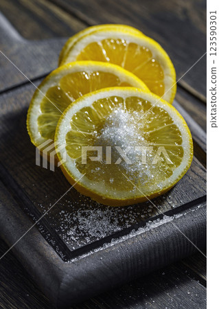 Lemon wedges garnished with sugar on wooden tray Lemon wedges garnished with sugar on wooden tray 123590301