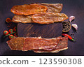 Snack platter with dried meat cherry tomatoes garlic cloves and spice bowls 123590308