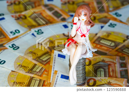 A young woman doll figurine in a swimsuit sits on a pile of coins on a background of euro banknotes A young woman doll figurine in a swimsuit sits on a pile of coins on a background of euro banknotes 123590888