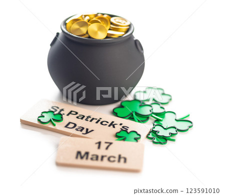 St. Patrick's Day. Green clover leaves decoration and cauldron with golden coins isolated on white background. St. Patrick's Day. Green clover leaves decoration and cauldron with golden coins isolated on white background. 123591010
