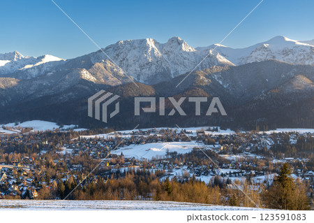 Stunning winter landscape of Zakopane, Poland, featuring the snow-covered Tatra Mountains at sunset. The picturesque alpine town, surrounded by forests and peaks, offers breathtaking views and is a po Stunning winter landscape of Zakopane, Poland, featuring the snow-covered Tatra Mountains at sunset. The picturesque alpine town, surrounded by forests and peaks, offers breathtaking views and is a po 123591083