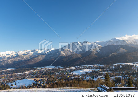 Stunning winter landscape of Zakopane, Poland, featuring the snow-covered Tatra Mountains at sunset. The picturesque alpine town, surrounded by forests and peaks, offers breathtaking views and is a po Stunning winter landscape of Zakopane, Poland, featuring the snow-covered Tatra Mountains at sunset. The picturesque alpine town, surrounded by forests and peaks, offers breathtaking views and is a po 123591088