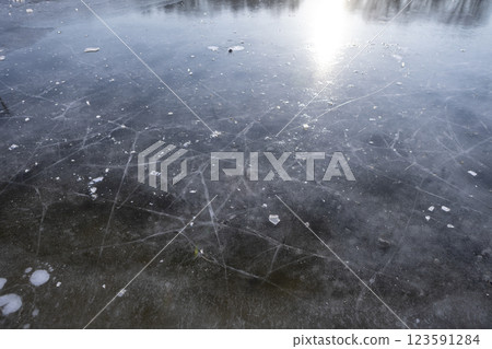 walking on transparent ice covering a frozen winter river 123591284