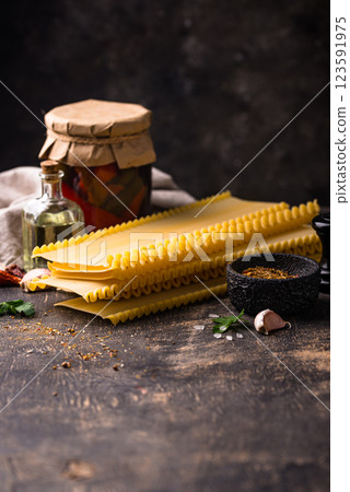 Uncooked lasagna pasta with cooking ingredient Uncooked lasagna pasta with cooking ingredient 123591975