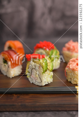 Japan menu Close up set of sushi roll with rice and fish on wooden serving board. Dark black texture background with copy space. Asian food 123592275