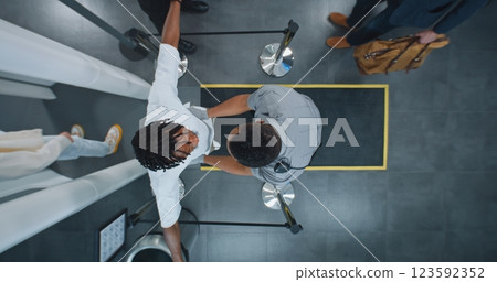 Diverse People Passing Through X-ray Metal Detector Scanner, Airport Worker Checking Passengers Diverse People Passing Through X-ray Metal Detector Scanner, Airport Worker Checking Passengers 123592352