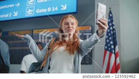 Crowded Airport Terminal: Young Woman Talking on Phone by Video Call, Recording Video Content Crowded Airport Terminal: Young Woman Talking on Phone by Video Call, Recording Video Content 123592462