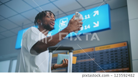 Crowded Airport Terminal: Man Talking on Phone by Video Call, Recording Video Content Crowded Airport Terminal: Man Talking on Phone by Video Call, Recording Video Content 123592482