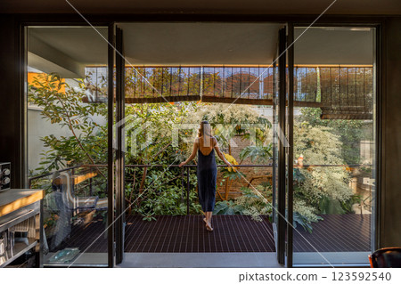 Woman Enjoying Nature on a Modern Balcony Woman Enjoying Nature on a Modern Balcony 123592540