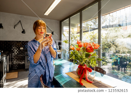 Woman Using Smartphone in a Bright Modern Kitchen 123592615