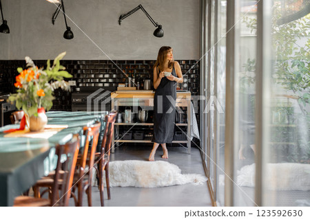 Woman Enjoying Coffee in a Modern Kitchen 123592630