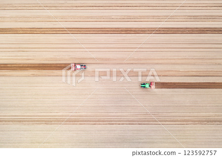Top-down view of an agricultural landscape with a two tractors 123592757