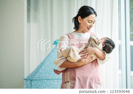 一名女托兒所老師抱著一名新生嬰兒 123593046