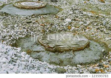 Preparing.Road repair. Sewer manholes covered with cement mortar 123593783