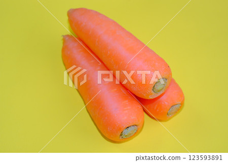 Fresh carrots photographed against a yellow background 123593891