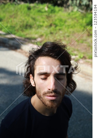Italian Man with Long Hair Breathes Concentrated Pure Air in the Mountains Italian Man with Long Hair Breathes Concentrated Pure Air in the Mountains 123594194
