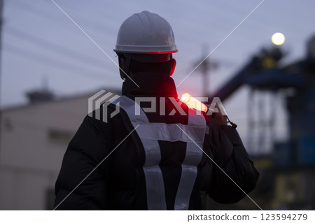 A worker directing traffic 123594279