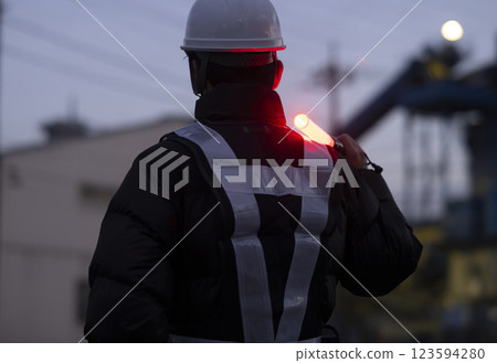 A worker directing traffic 123594280