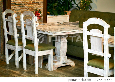 Small retro wooden table in a cafe with massive chairs Small retro wooden table in a cafe with massive chairs 123594368