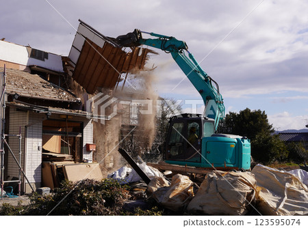 Demolition of vacant houses using heavy machinery Demolition of a dilapidated wooden house 123595074