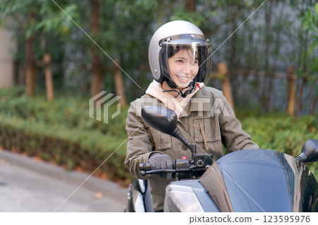 騎摩托車的年輕女子 騎摩托車的年輕女子 123595976