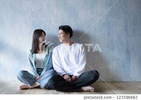 A couple looking at each other with a gentle smile in the light of the gentle, pale sunlight. Wide-angle shot of the whole body. Copy space available. Marriage or couple 123596662