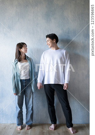 A couple standing close together, gazing at each other with a gentle smile in the light of soft sunlight, copy space available 123596665