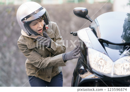 一名女子對一輛摩托車的車身感到驚訝 123596874