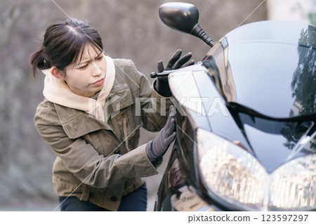 一名女子檢查摩托車車身 123597297