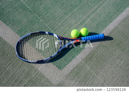 Racket and ball on a tennis court Racket and ball on a tennis court 123598126