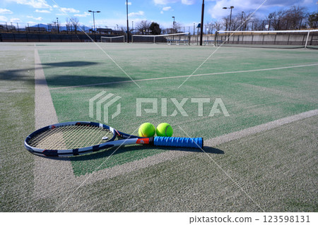 Racket and ball on a tennis court 123598131