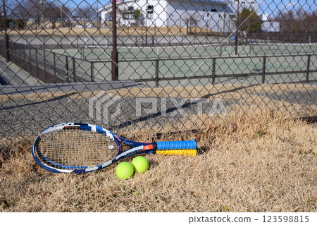 Rackets and balls outside a tennis court Rackets and balls outside a tennis court 123598815