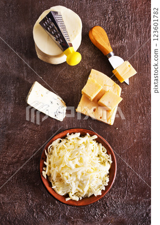 Shredded mozzarella and red cheddar cheese on cutting board 123601782