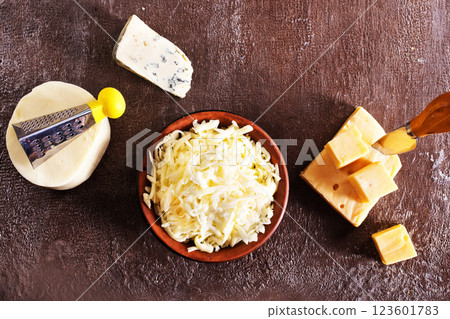 Shredded mozzarella and red cheddar cheese on cutting board 123601783