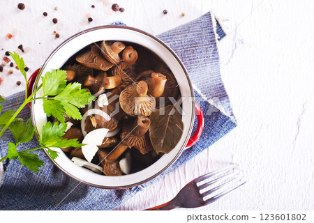 Pickled mushrooms in a metal bowl. Marinated mushrooms with pepper and bay leaf. 123601802